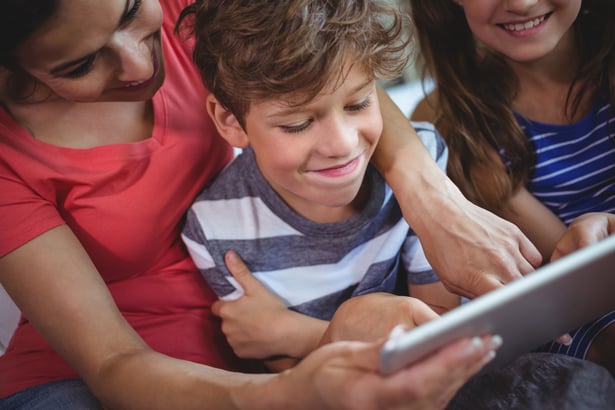 Close-up of mother and kids using digital tablet together at home
