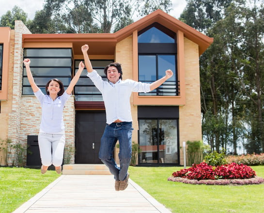 Excited couple jumping after buying a house