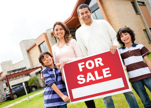 Happy family holding poster of a house for sale-1