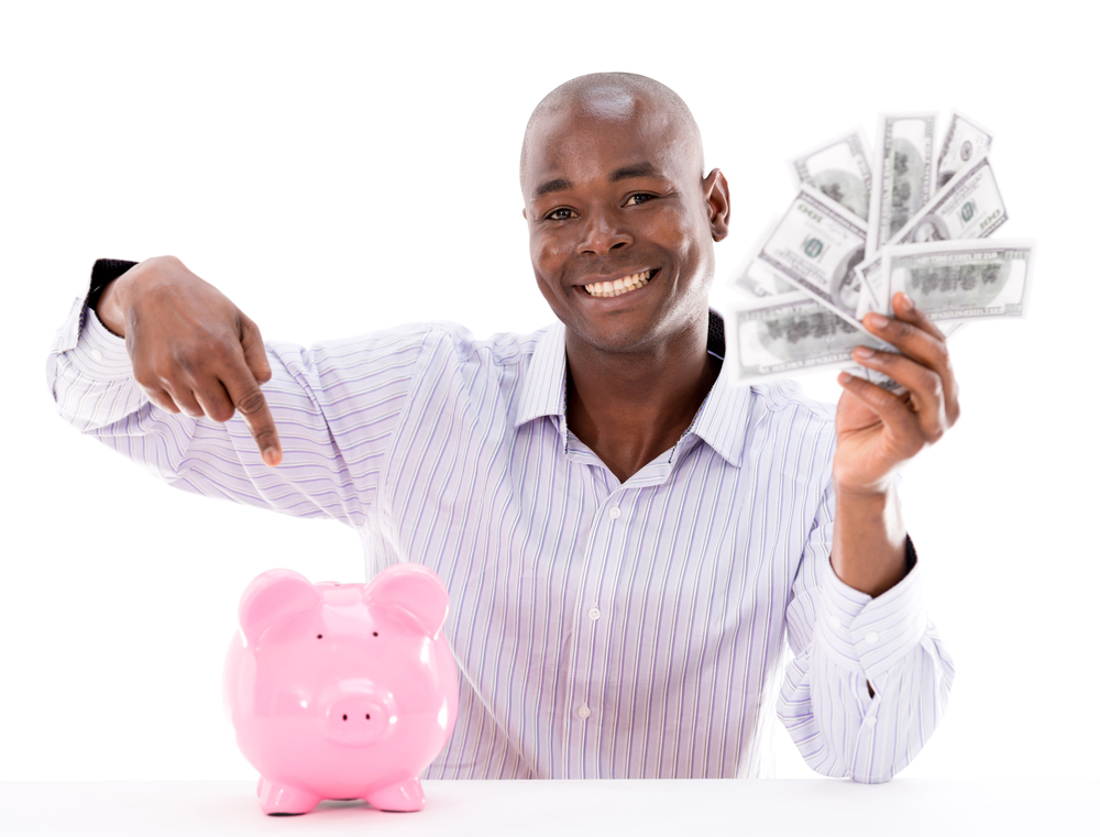 Happy man saving money in a piggybank - isolated over white
