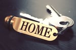 Keys and Golden Keyring with the Word Home over Black Wooden Table with Blur Effect. Toned Image.-1